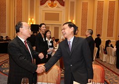 澳門緬華互助會會長黃國賢（右）向澳門潮州同鄉(xiāng)會理事長陳新濤握手問好
